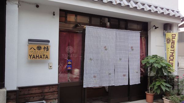 The entrance to a home with a sign reading Yahata and a flag that reads guesthouse